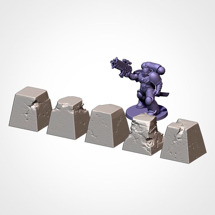 Concrete pyramids and barriers, shown beside a 32mm miniature for scale